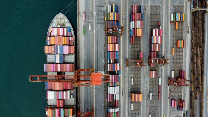 Cargo ship loaded with colorful containers at a busy port.